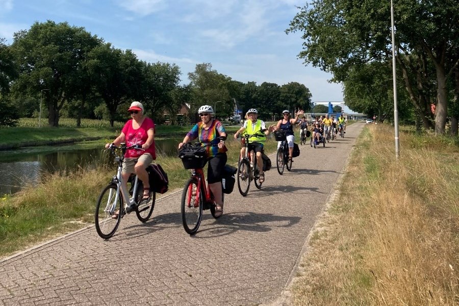 Groep mensen fietst langs het Stieltjeskanaal. 